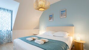 Une chambre à coucher avec un lit, une table de chevet, une lampe et une fenêtre avec des rideaux.