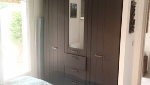 A bedroom with a bed, a wardrobe, and a window.