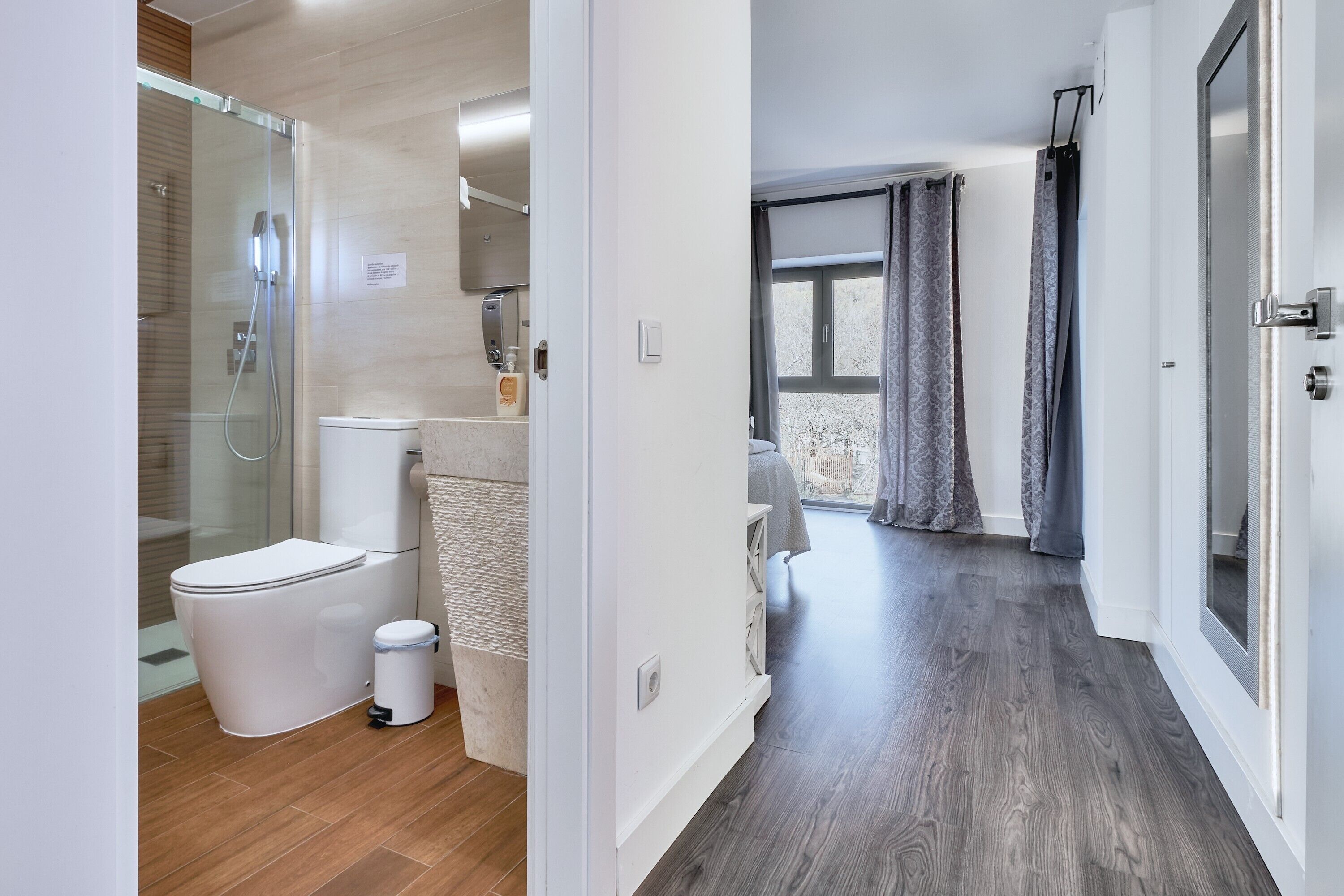 Ein modernes Badezimmer mit Duschkabine aus Glas, Toilette und Waschbecken.