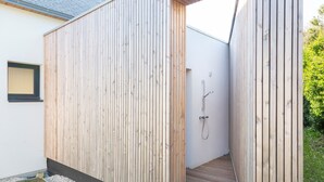 Un mur extérieur en bois avec une douche intégrée.