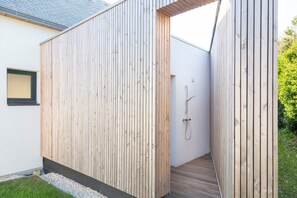 Pared exterior de madera con ducha integrada.