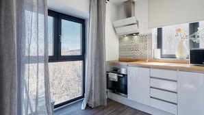 A modern kitchen with a large window, a built-in oven, and a wooden countertop. - Apartment 'Marel' with Mountain View, Wi-Fi and Air Conditioning (Cerdillo de Sanabria)