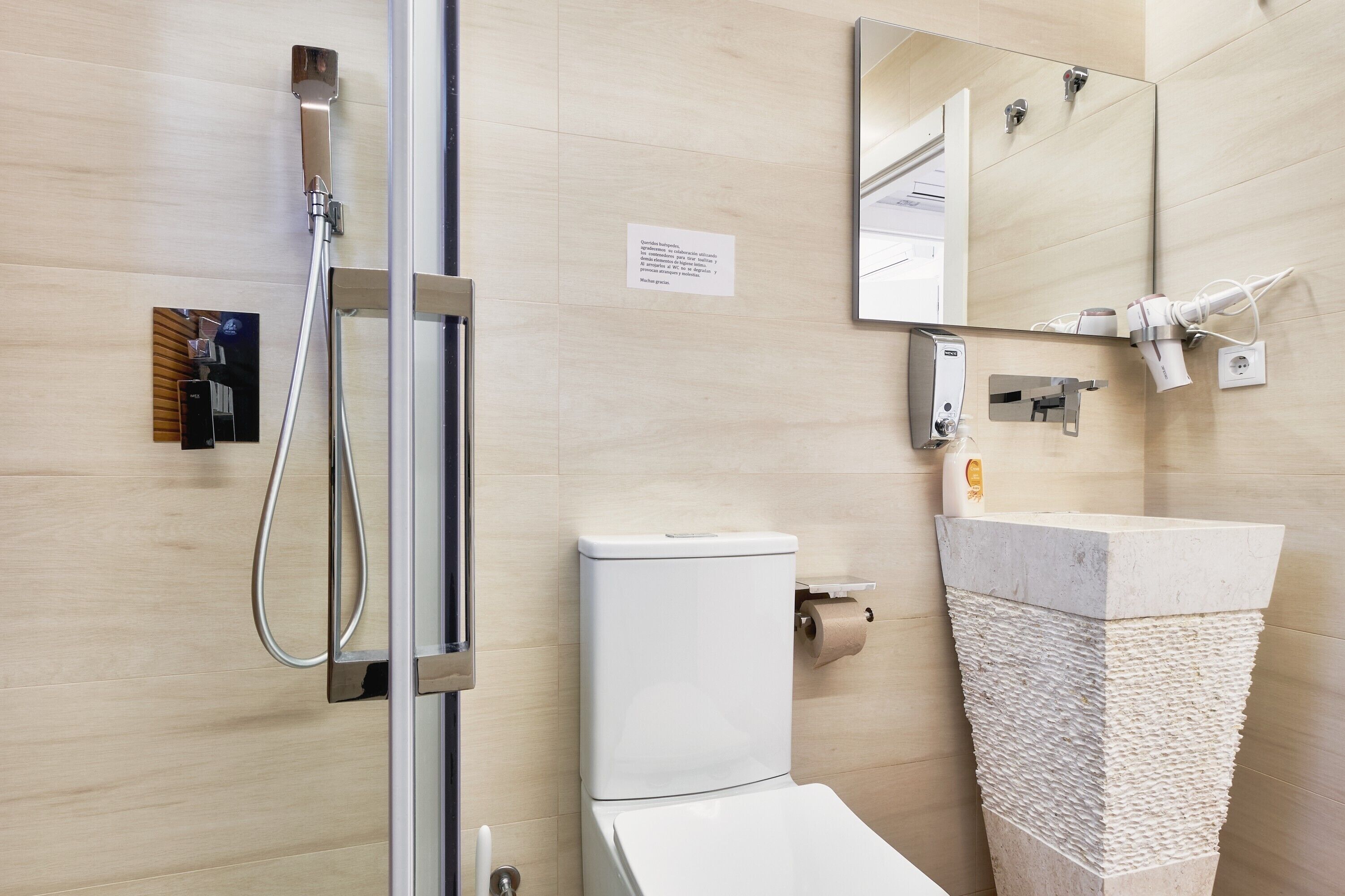 A modern bathroom with a shower, toilet, and sink.