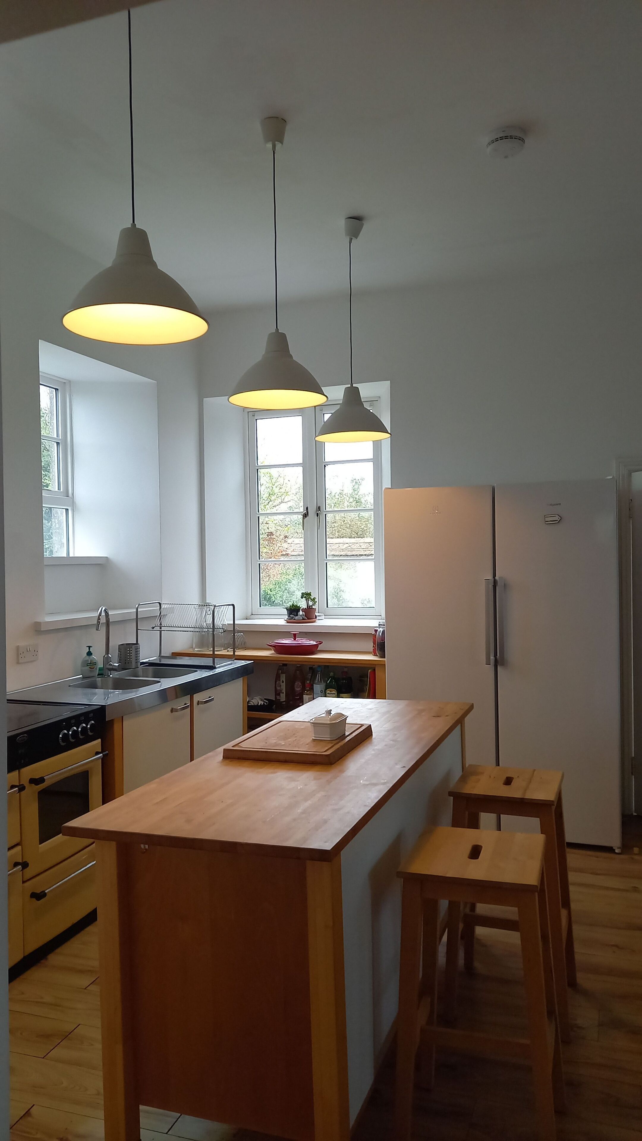 Een koelkast, een vaatwasser, kookgerei, borden en bestek, een eettafel