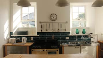 Kylskåp, diskmaskin, grytor/köksredskap och matbord