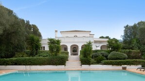 A pool with a clear blue water surface, surrounded by a white building with a tiled roof, and a staircase leading to the entrance. - Holiday Home 'Birdie' with Private Pool, Wi-Fi, and Air Conditioning (Benalup-Casas Viejas)