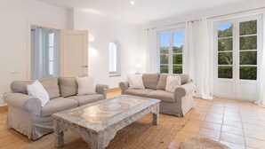 A spacious living room with two sofas, a patterned coffee table, and large windows with curtains. - Holiday Home 'Birdie' with Private Pool, Wi-Fi, and Air Conditioning (Benalup-Casas Viejas)