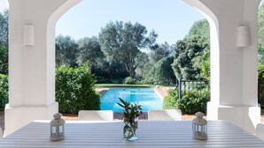 A poolside view with a white pergola, a clear blue pool, and lush greenery. - Villa 'Eagle' with Private Pool, Wi-Fi, and Air Conditioning (Benalup-Casas Viejas)
