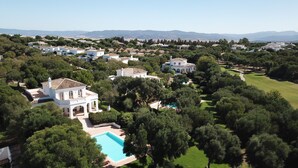 A residential area with multiple houses, a swimming pool, and a golf course. - Villa 'Eagle' with Private Pool, Wi-Fi, and Air Conditioning (Benalup-Casas Viejas)