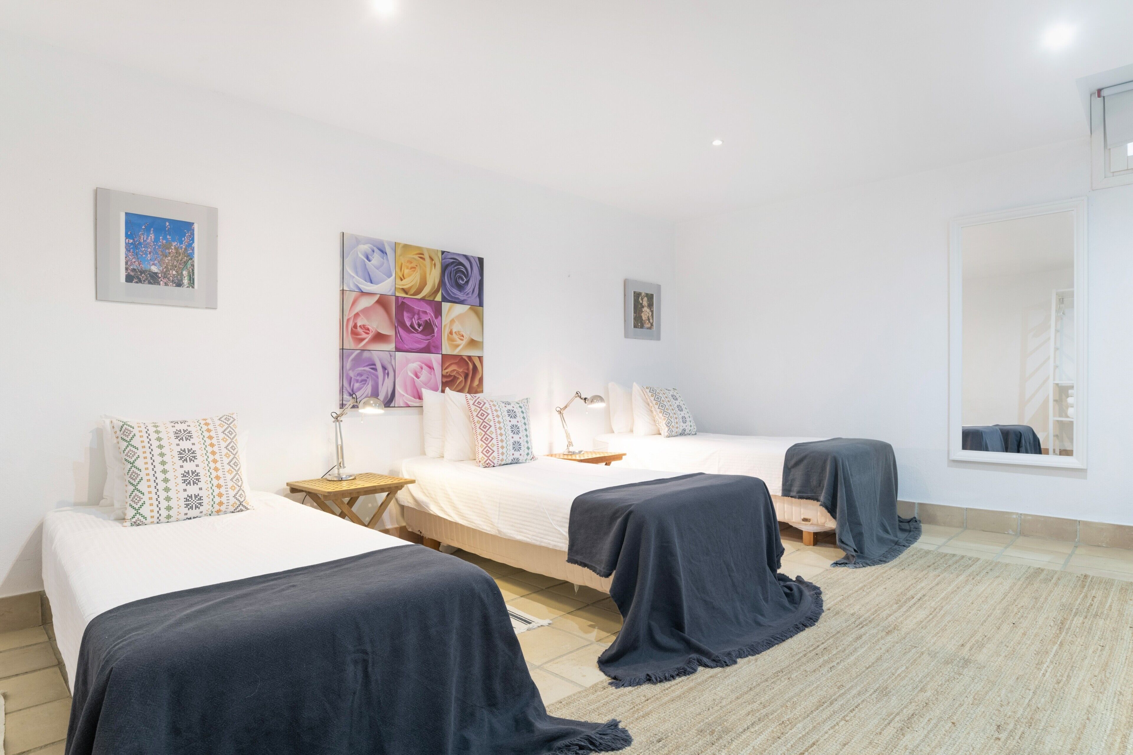 Une chambre d’hôtel avec deux lits, un grand miroir et une œuvre d’art murale.