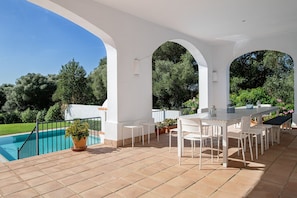 A covered outdoor patio with a pool, white furniture, and a view of the surrounding greenery. - Holiday Home 'Albatros' with Private Pool, Wi-Fi and Air Conditioning (Benalup-Casas Viejas)