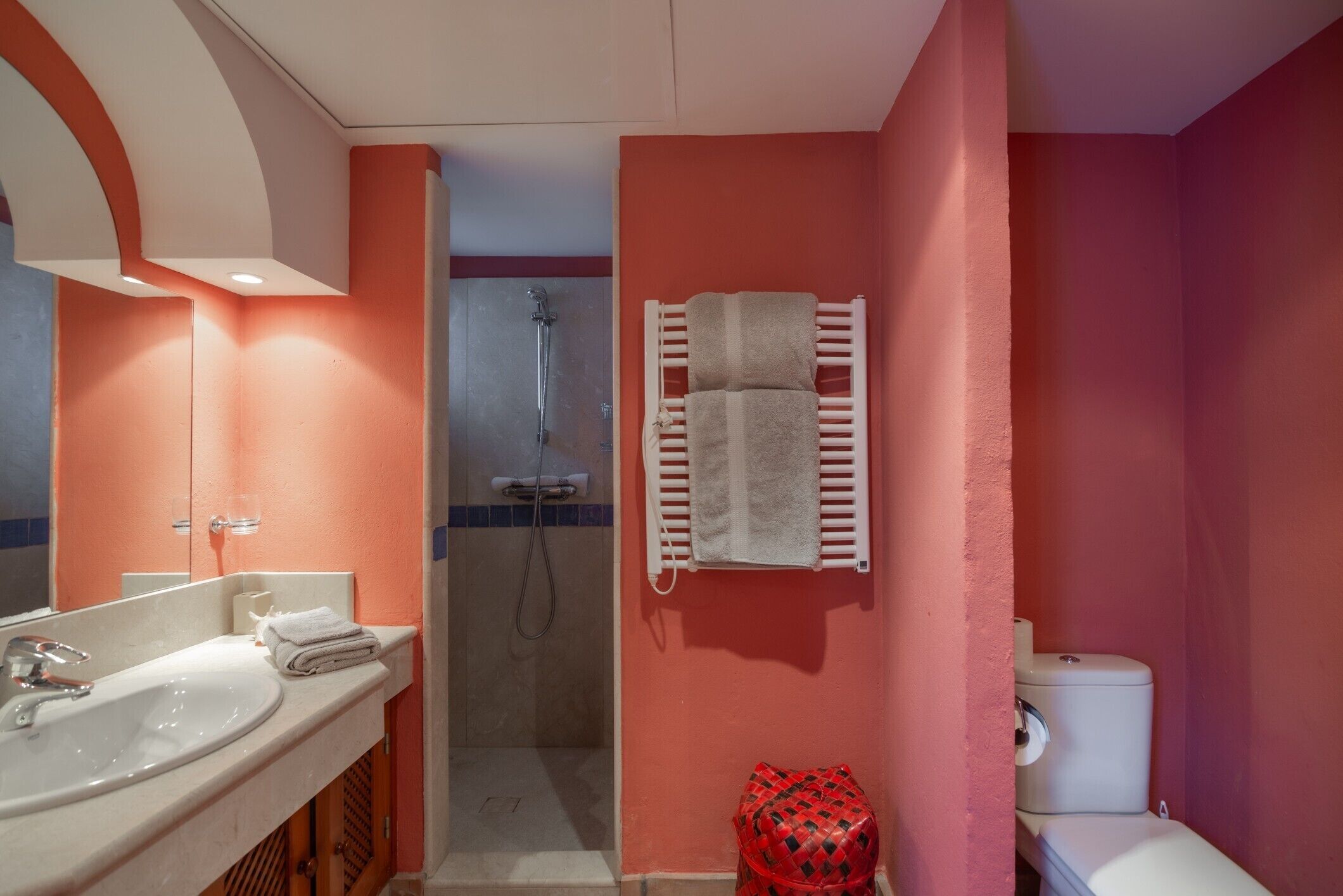 Un baño con lavabo, espejo, ducha e inodoro.