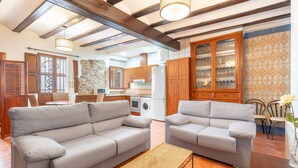 A living room with two sofas, a coffee table, and a kitchen in the background.