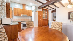 A kitchen with wooden cabinets, a round dining table, and a built-in oven.
