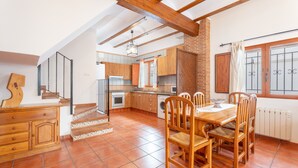 A spacious kitchen with wooden cabinets, a dining table, and chairs. - Country House 'Cueva De La Portería' with Mountain View and Wi-Fi (Chulilla)