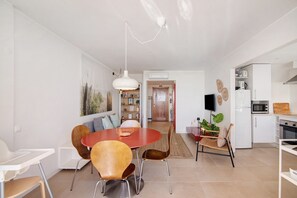 Een moderne keuken met witte kastjes, een magnetron en een fornuis.