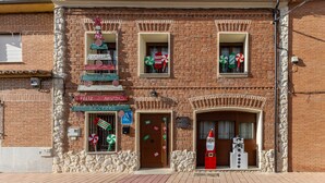 Ein Backsteinhaus mit vielen Fenstern, von denen einige mit Weihnachtsdekorationen geschmückt sind.