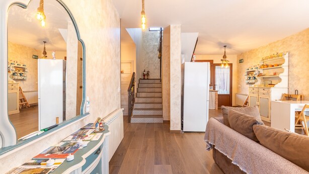 Ein geräumiger Wohnbereich mit Treppe, Sofa und Essbereich.