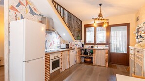 Eine Küche mit Kühlschrank, Backofen, Mikrowelle und Spüle.