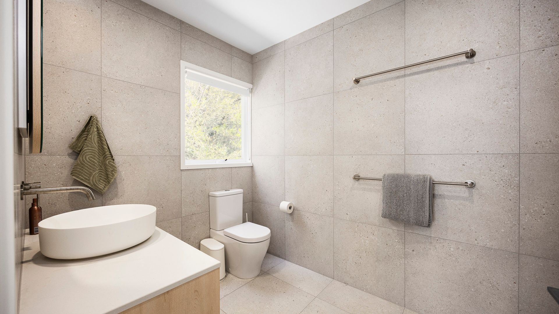 Une salle de bain moderne avec une baignoire sur pieds, des toilettes et un porte-serviettes.