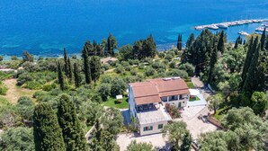 A coastal property with a view of the sea, a marina, and surrounding greenery. - Room 'Two Bedroom' with Private Terrace, Wi-Fi and Air Conditioning (Corfu)