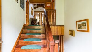 Una escalera de madera con escalones verdes que conduce a una habitación con una mesa de comedor y sillas.
