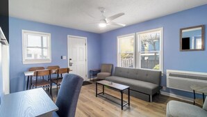 A living room with a sofa, chairs, a coffee table, and a dining area with a table and chairs.