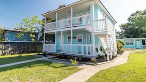 A two-story building with a white porch and a blue exterior.
