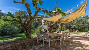 An outdoor patio with a table and chairs, surrounded by stone walls and trees. - Holiday Home 'Maison - Les Bergeries De Danielle' with Private Pool, Private Terrace and Wi-Fi (Draguignan)
