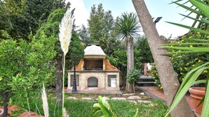 A stone building with a dome roof, surrounded by lush greenery and trees. - Cozy apartment in Trecastagni with swimming pool (Trecastagni)