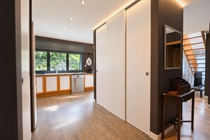A modern kitchen with a window, a dishwasher, and a wooden cabinet.