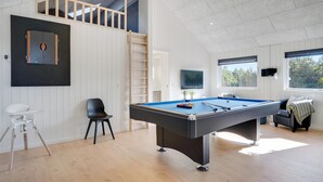A modern room with a pool table, a TV, and a loft area with a wooden ladder. - Lovely home in Vejers Strand with sauna (Vejers Strand)
