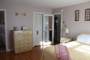 A bedroom with a bed, dresser, and a walk-in closet. - Patsy Cline's Dream Home (Goodlettsville)