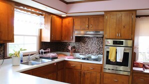 A kitchen with wooden cabinets, a stainless steel range, and a tiled backsplash.