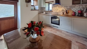 A kitchen with white cabinets, a built-in oven, and patterned backsplash tiles. - 2 bedroom nice home in Caden (Caden)