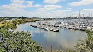 A marina with numerous boats docked along the water's edge, surrounded by greenery and a clear sky. - 2 bedroom nice home in Caden (Caden)