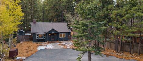 A house with a dark exterior, a sloped roof, and a front porch.