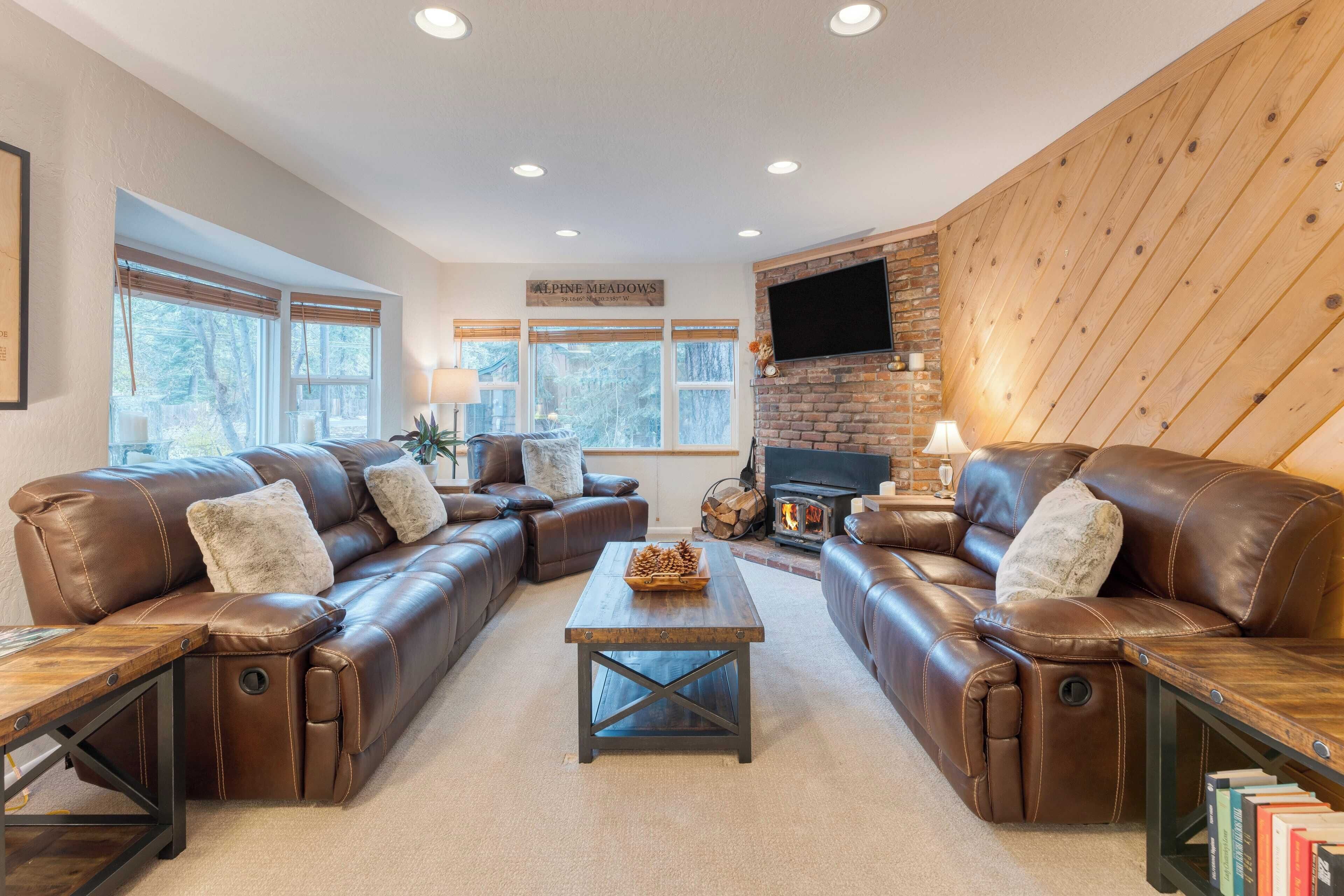 A cozy living room with leather sofas, a wooden coffee table, and a fireplace.