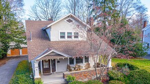 A two-story house with a front porch, a brick entryway, and a garage.