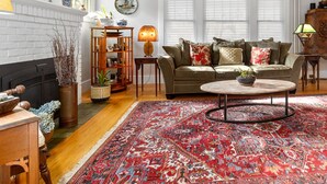A living room with a patterned rug, a sofa, a coffee table, and a fireplace.