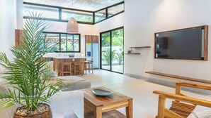 A modern living room with a wooden coffee table, a sofa, and a potted plant.