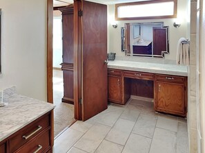 A bathroom with wooden cabinets, a marble countertop, and a large mirror. - The Seagulls Nest by Silver Sands Vacation Rentals (Port Aransas)