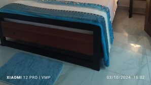 Ein Schlafzimmer mit einem Bett, zwei Nachttischen mit Lampen, einer blauen Matte und einem Datumsstempel.
