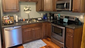Una cocina con armarios de madera, electrodomésticos de acero inoxidable y un letrero con la palabra 'hello'.
