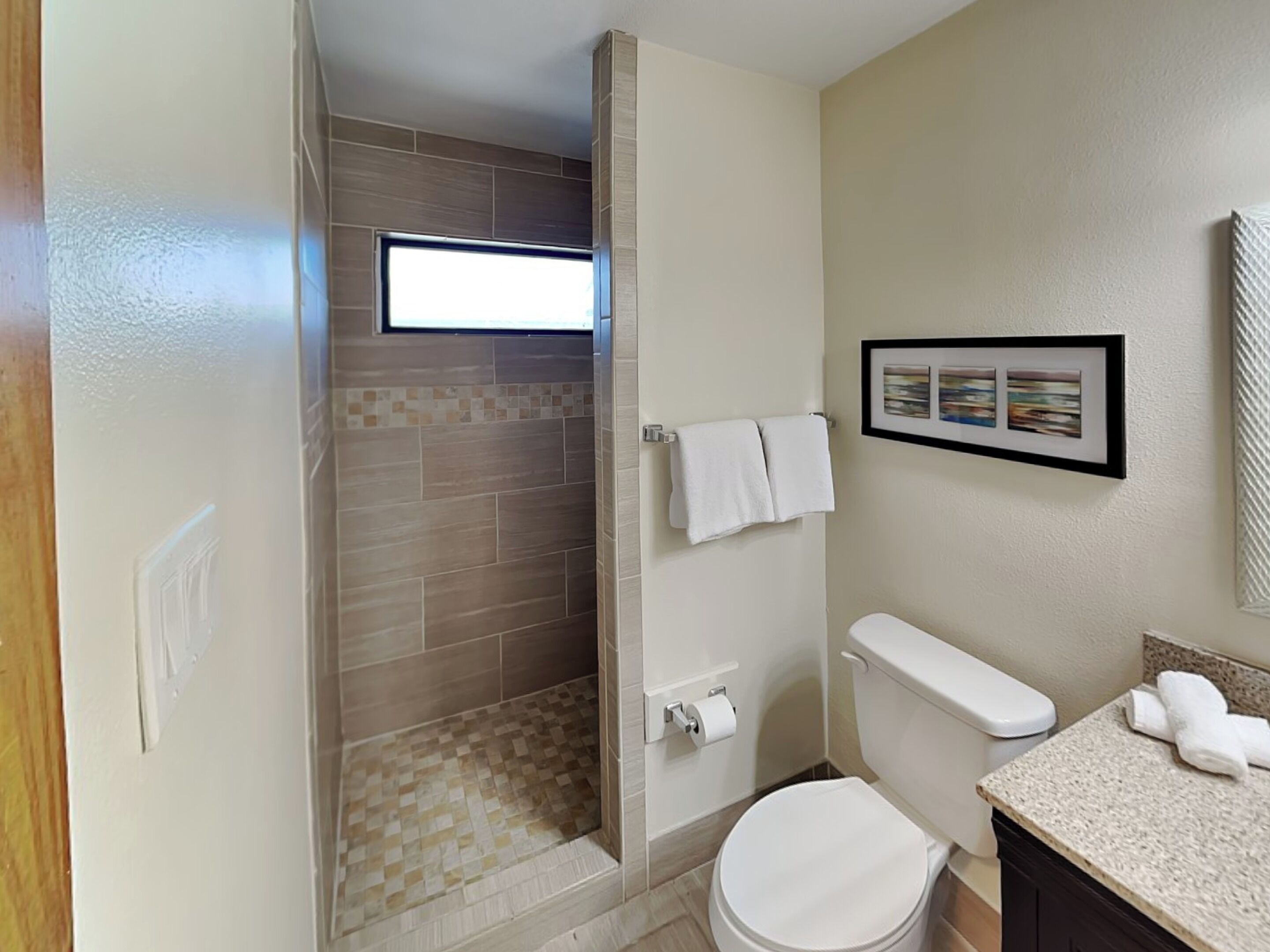 A bathroom with a shower, toilet, and sink.
