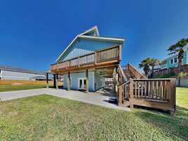 A two-story house with a balcony, a covered porch, and a wooden deck.