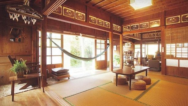 A wooden interior with tatami mats, a hammock, and a traditional Japanese-style room.