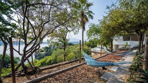 A hammock on a stone pathway with a view of a lake and trees. - Luxury House Pool fire Pit & Lake view (Jojutla)