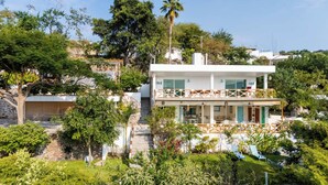 A two-story building with a balcony, surrounded by lush greenery and trees. - Luxury House Pool fire Pit & Lake view (Jojutla)