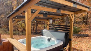 A hot tub under a wooden pergola in a wooded area. - Charming countryside home in the heart of Amish Country (Fredericktown)